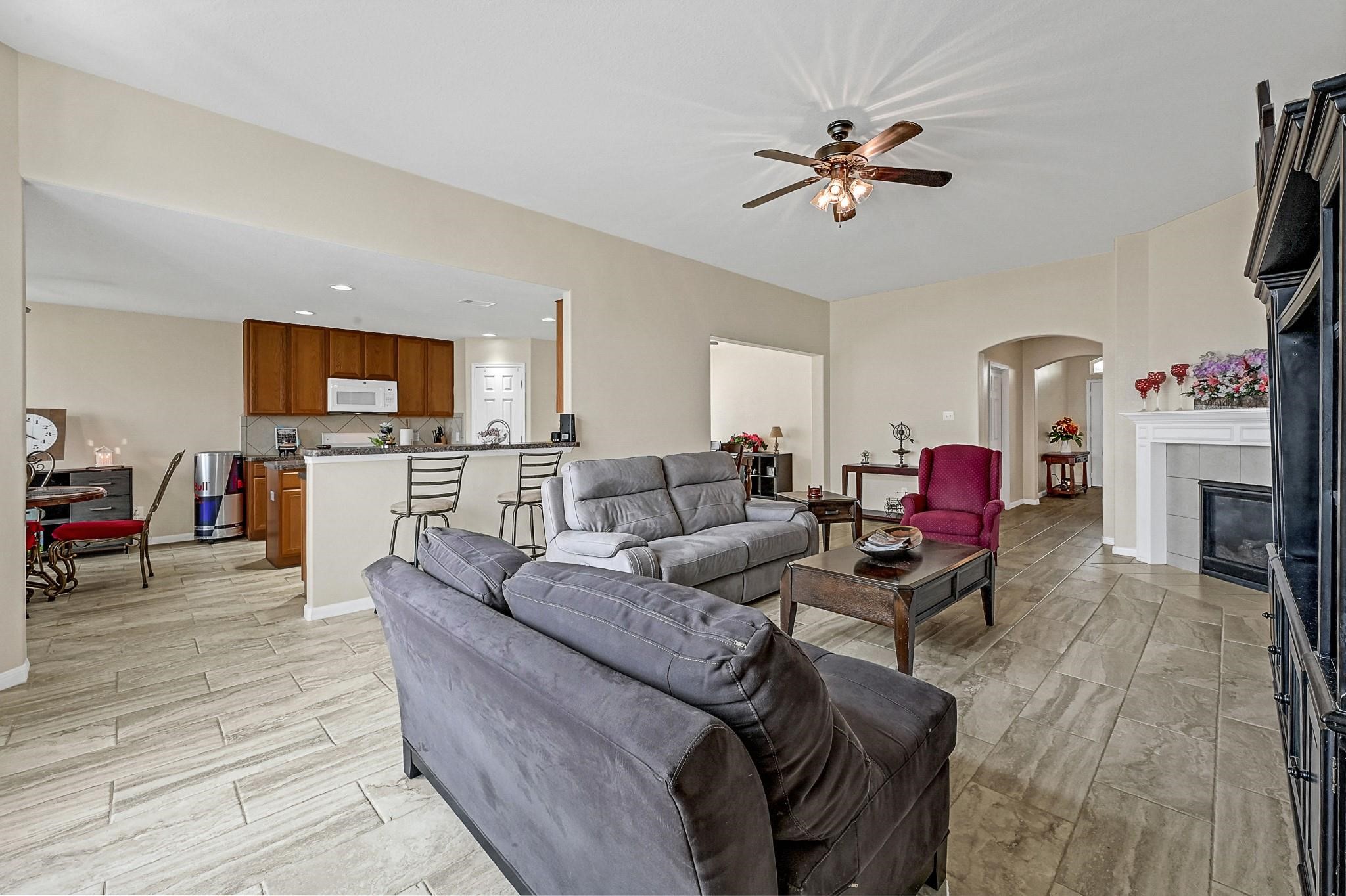 9920 Climbing Tree Street Conroe, TX 77385 - Photo 5 of 19 a living room with furniture a fireplace and a flat screen tv