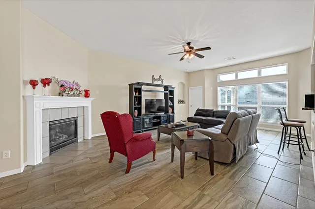 a living room with furniture a fireplace and a floor to ceiling window