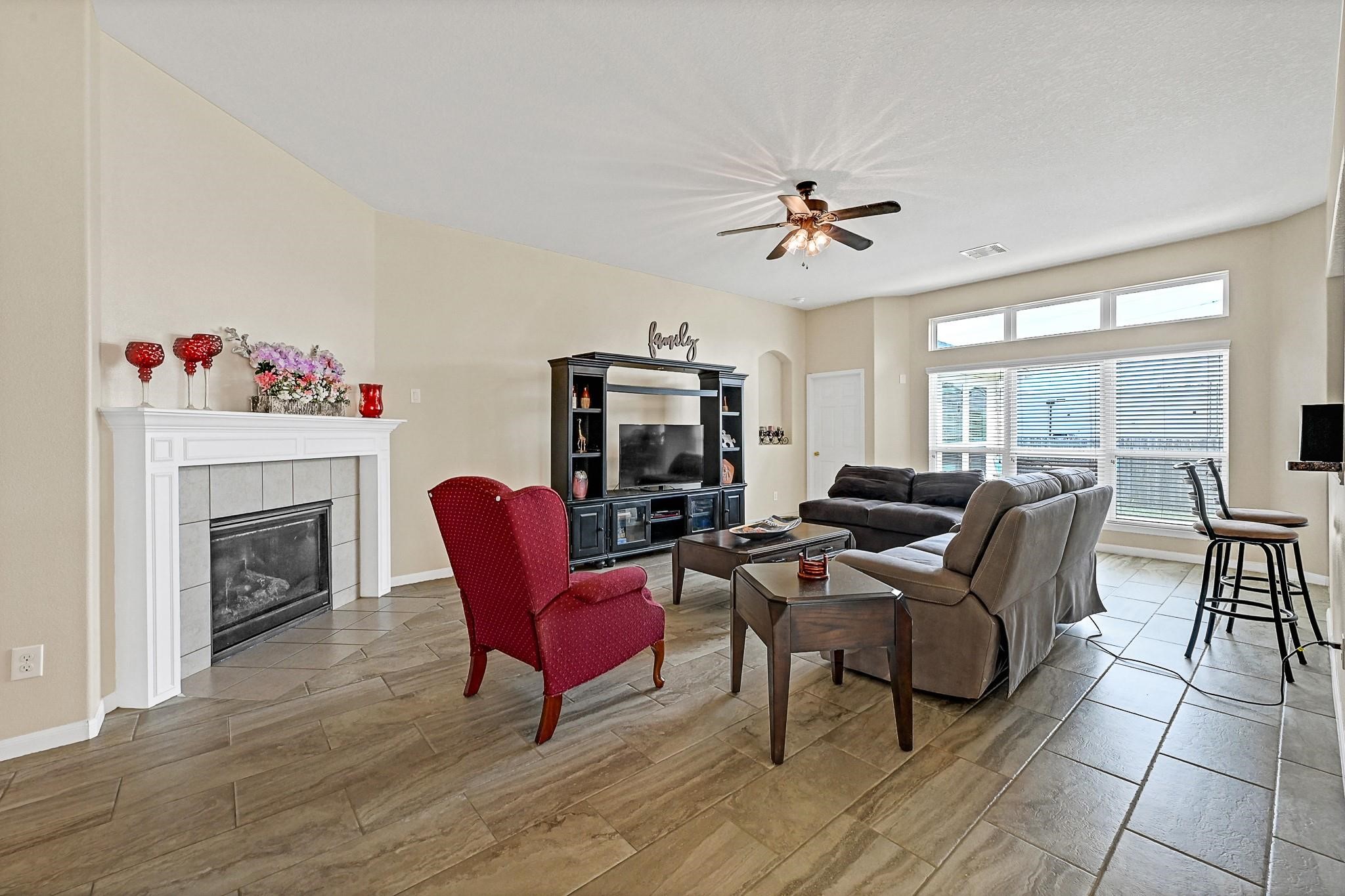 9920 Climbing Tree Street Conroe, TX 77385 - Photo 6 of 19 a living room with furniture a fireplace and a floor to ceiling window