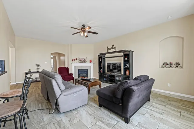 a living room with furniture a fireplace and a flat screen tv