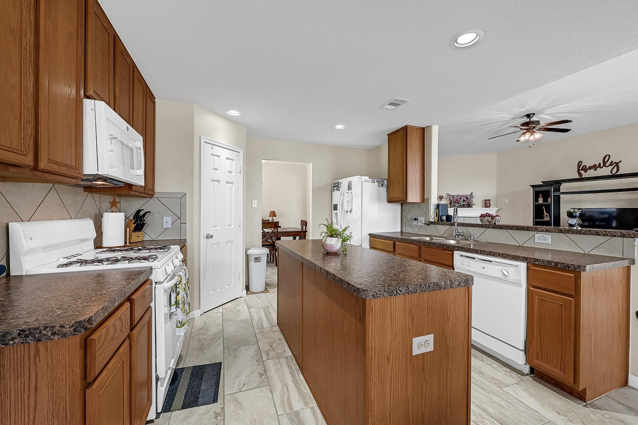 9920 Climbing Tree Street Conroe, TX 77385 - Photo 8 of 19 a kitchen with stainless steel appliances granite countertop a stove a sink dishwasher and a refrigerator