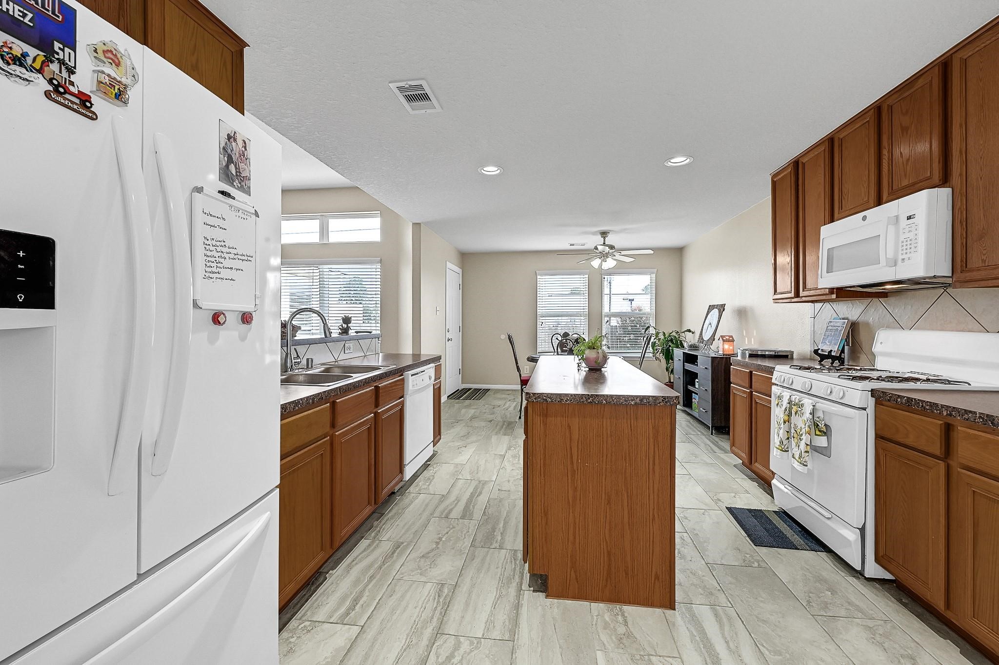 9920 Climbing Tree Street Conroe, TX 77385 - Photo 9 of 19 a large kitchen with stainless steel appliances granite countertop a stove and a sink