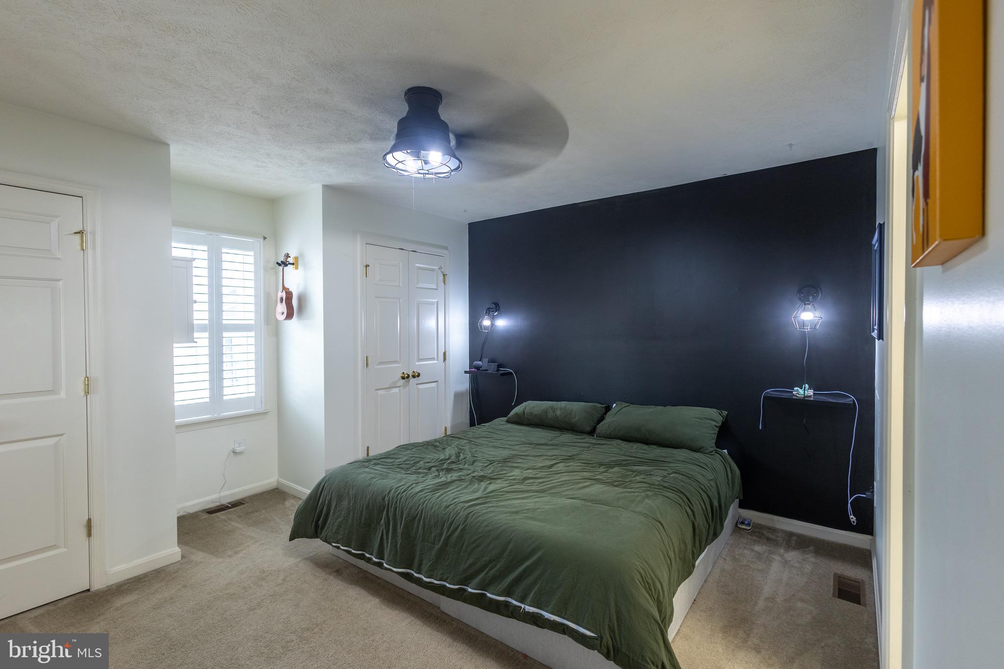 336 4th Street Colonial Beach, VA 22443 - Photo 20 of 23 a spacious bedroom with a bed and a chandelier