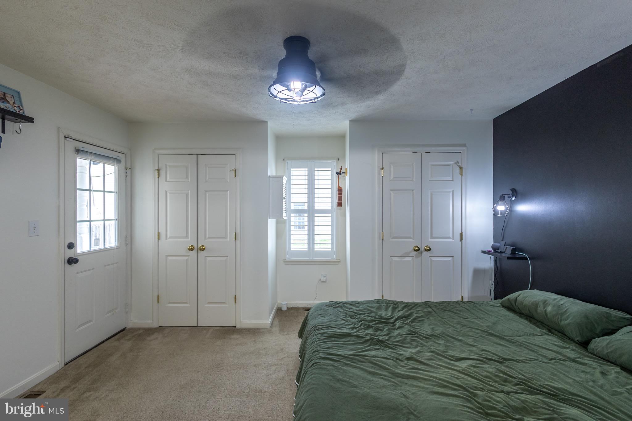 336 4th Street Colonial Beach, VA 22443 - Photo 22 of 23 a spacious bedroom with a bed and a chandelier