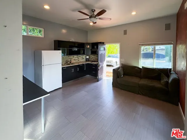 a living room with stainless steel appliances kitchen island granite countertop furniture and a fireplace