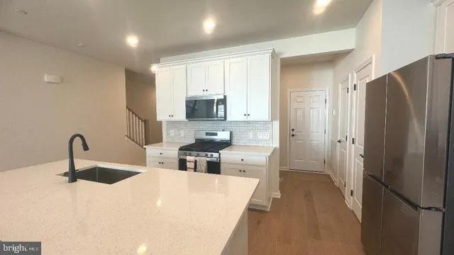 a kitchen with stainless steel appliances a refrigerator sink and cabinets