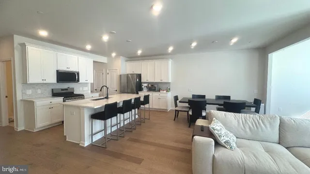 a living room with furniture and a view of kitchen