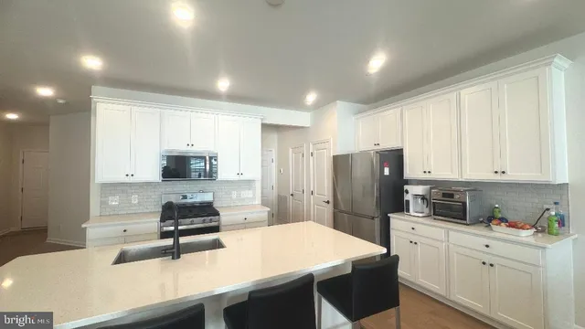 a kitchen with stainless steel appliances a refrigerator stove microwave and sink