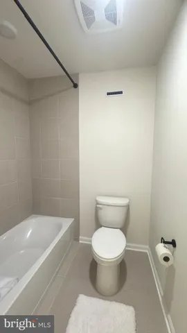 a white toilet sitting next to a bath tub