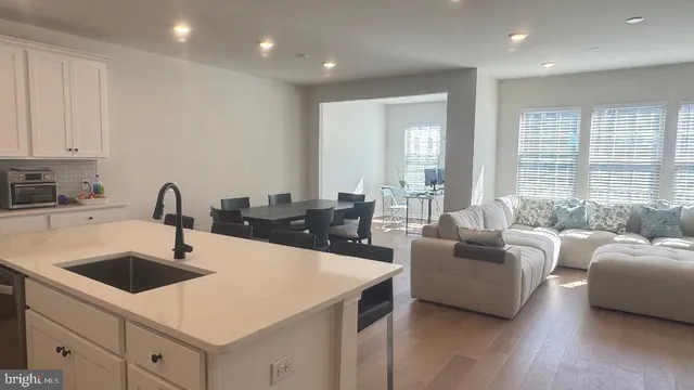 a kitchen with a sink a counter top space and living room area