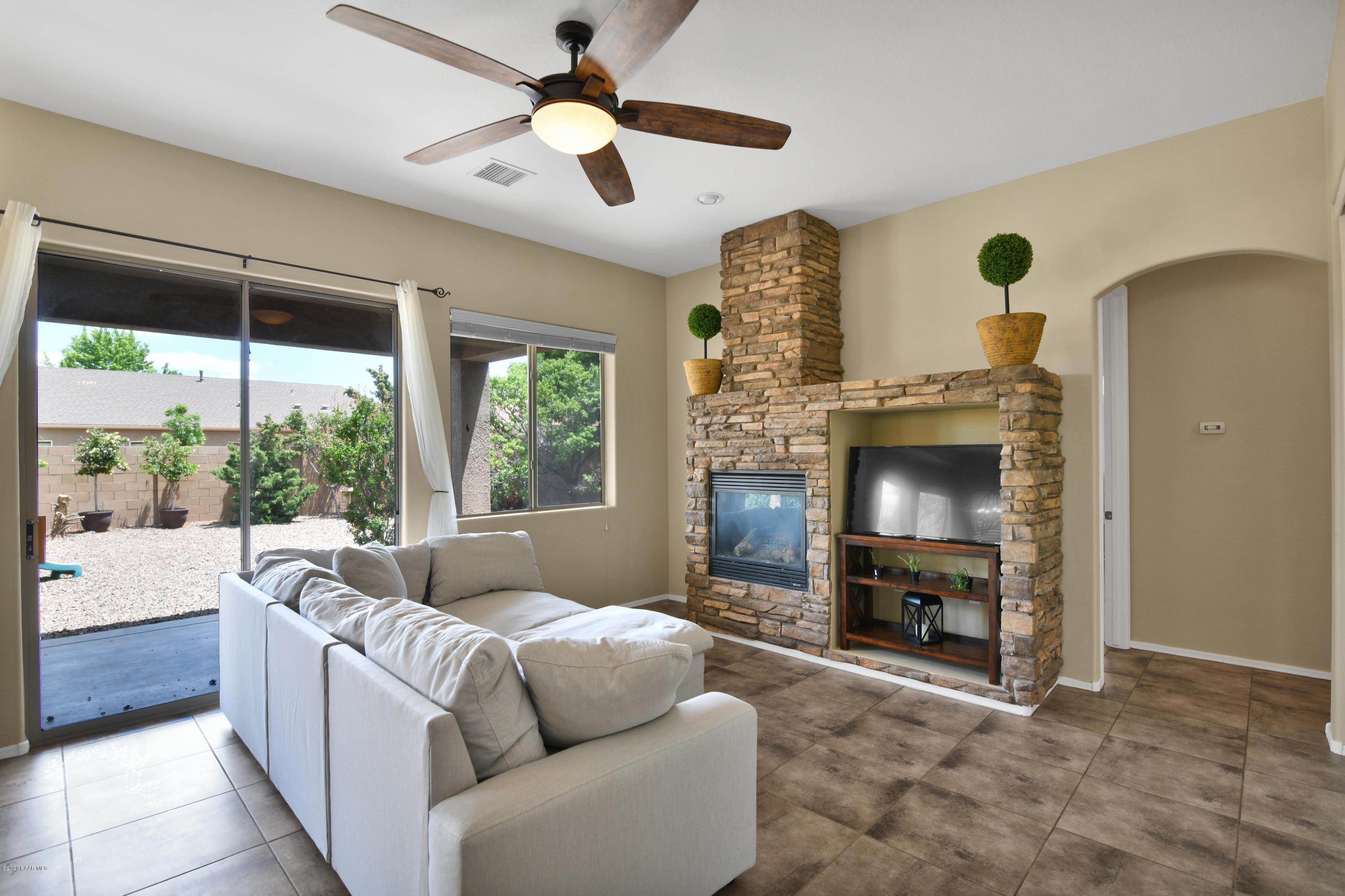 4825 Edgemont Road Prescott Valley, AZ 86314 - Photo 13 of 34 a living room with furniture a fireplace and a large window