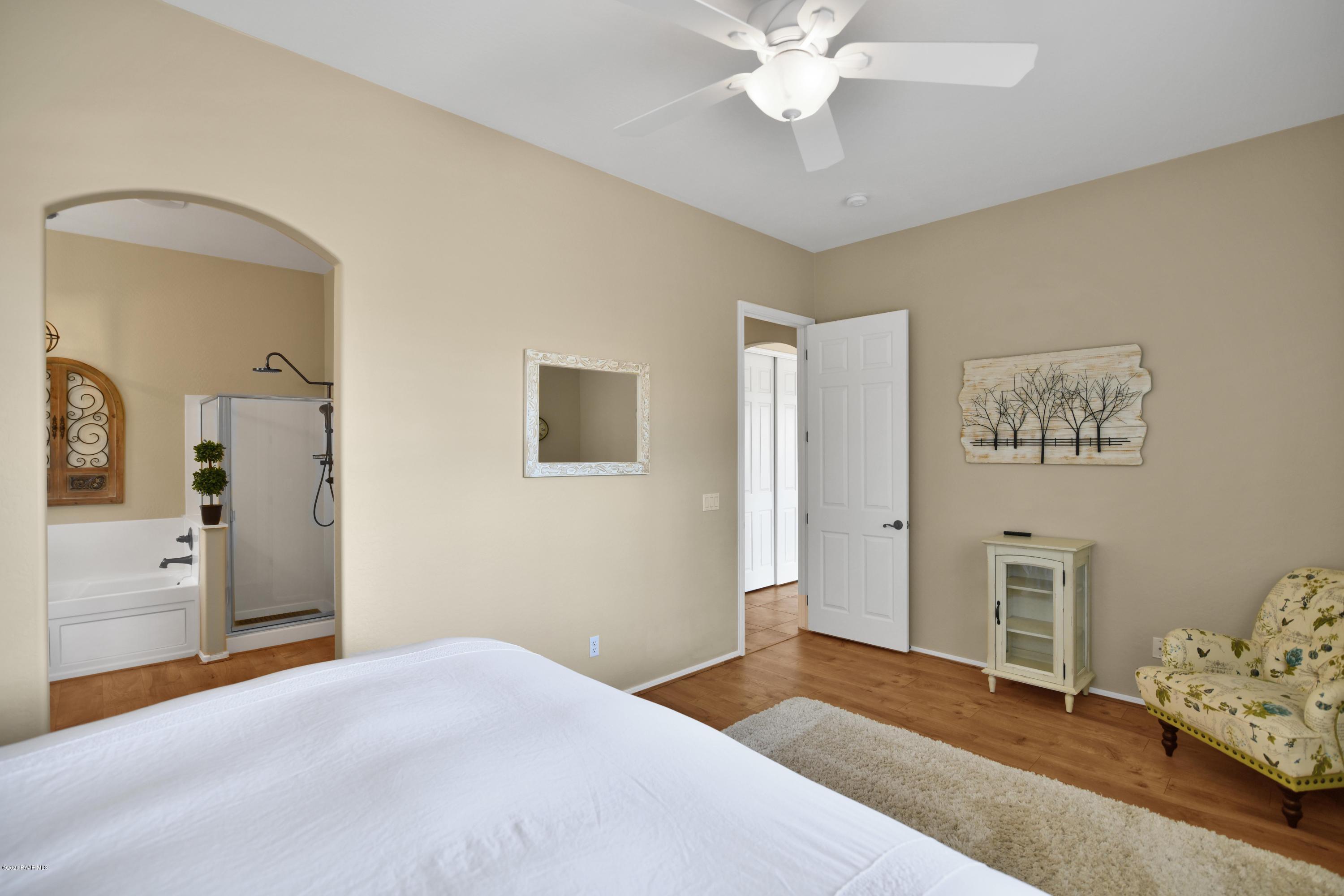 4825 Edgemont Road Prescott Valley, AZ 86314 - Photo 22 of 34 a bedroom with a bed and a chandelier