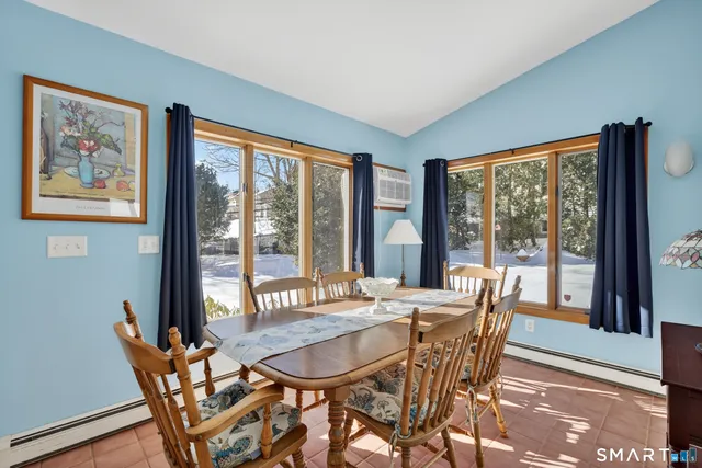 a view of a dining room with furniture large windows and wooden floor