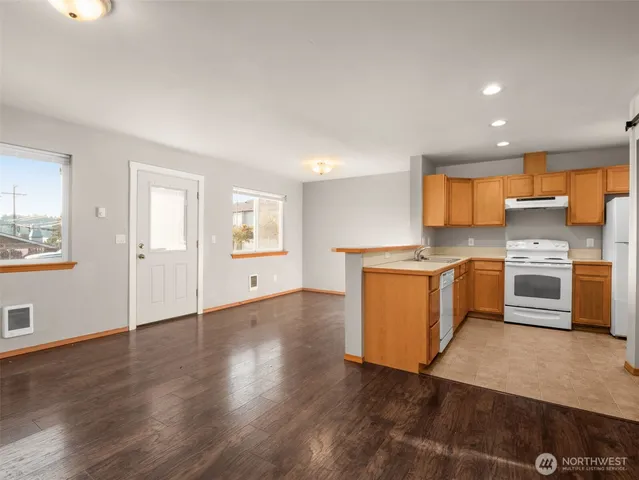 a view of a kitchen with a sink a stove top oven and cabinets