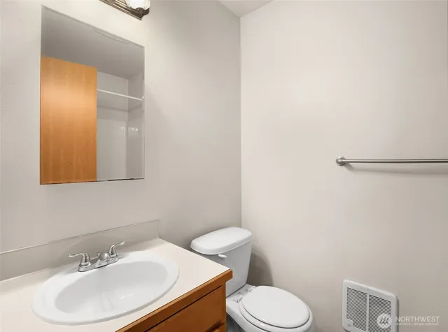 a bathroom with a sink a toilet and mirror