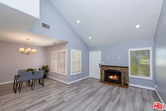 an empty room with wooden floor a fireplace and windows