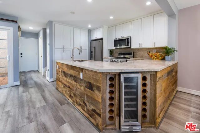 a kitchen with stainless steel appliances kitchen island granite countertop a stove a sink and a refrigerator