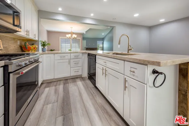a kitchen with cabinets a sink and appliances