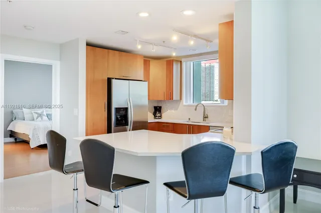 a large white kitchen with a dining table and chair