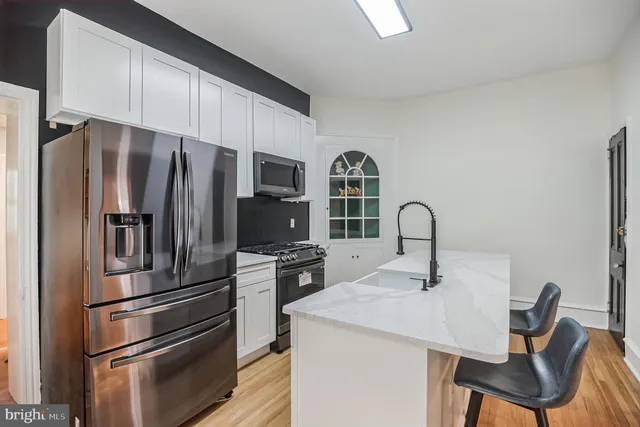 a kitchen with stainless steel appliances a refrigerator and a stove top oven