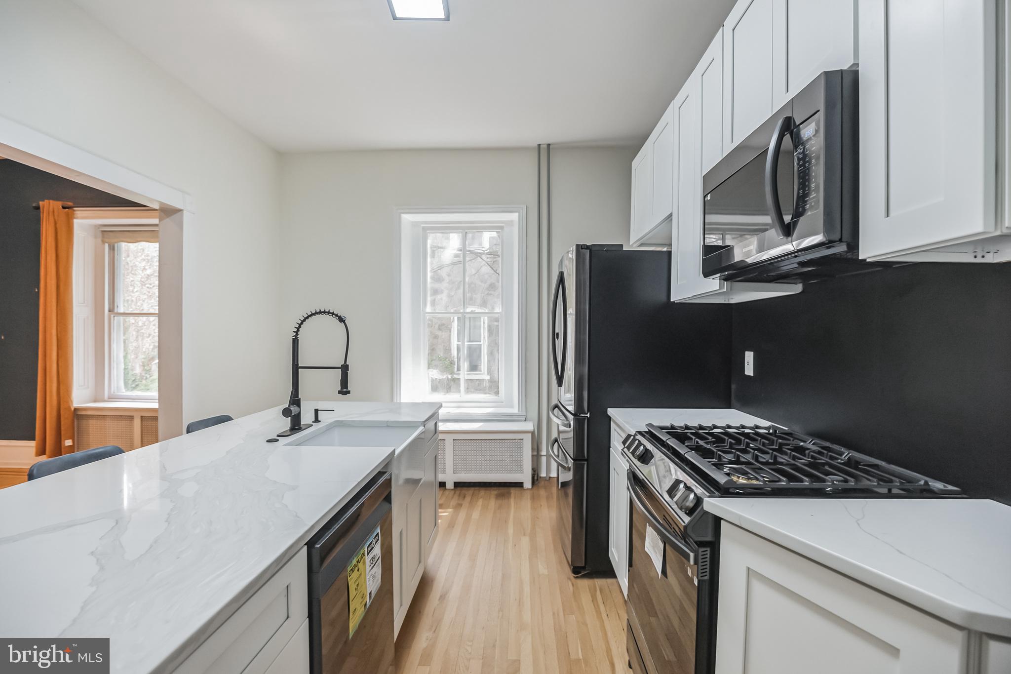 117 Rochelle Avenue Philadelphia, PA 19128 - Photo 12 of 29 a kitchen with stainless steel appliances a sink stove and refrigerator