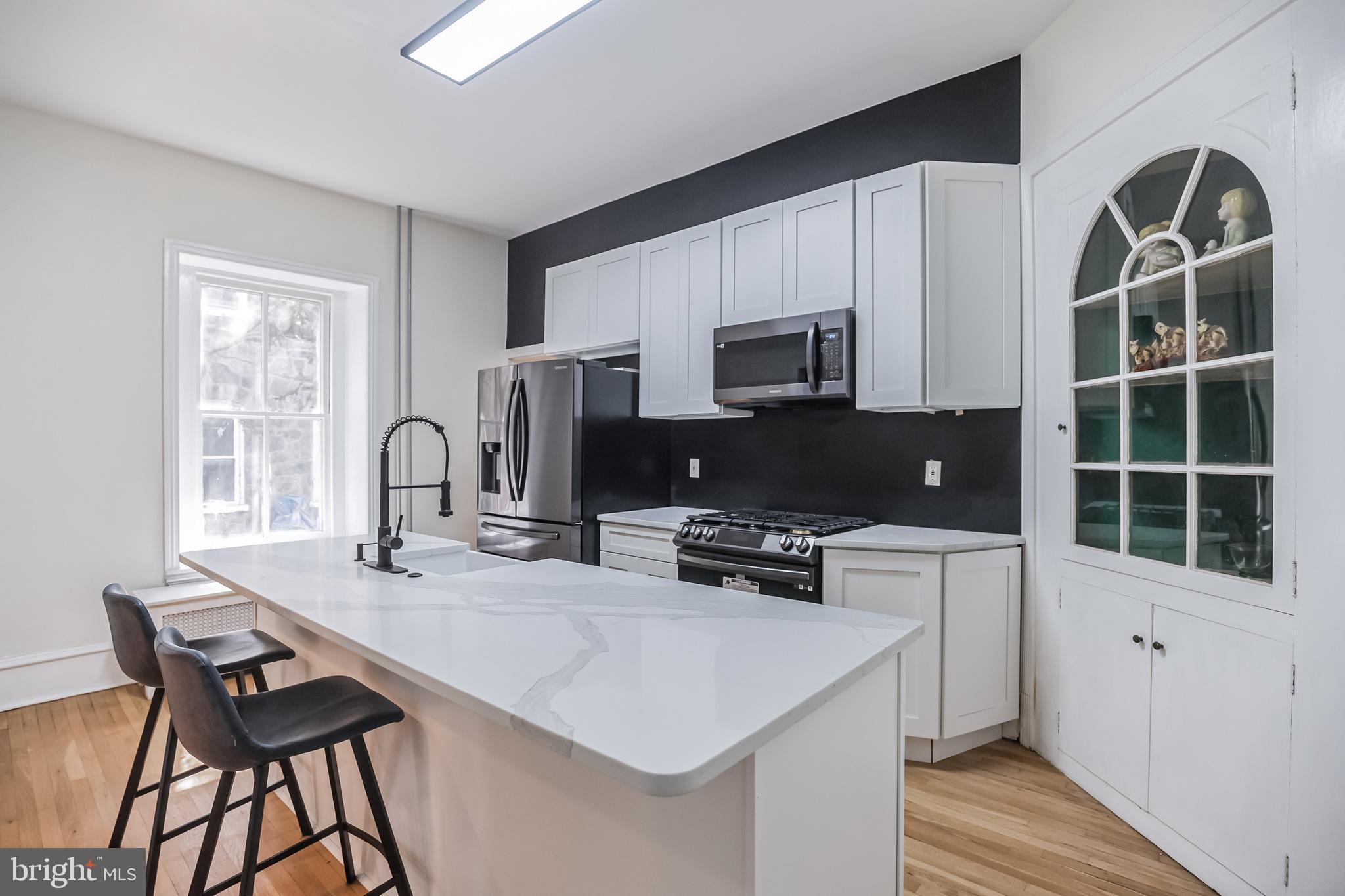 117 Rochelle Avenue Philadelphia, PA 19128 - Photo 9 of 29 a kitchen with stainless steel appliances a stove a sink a microwave a refrigerator and cabinets