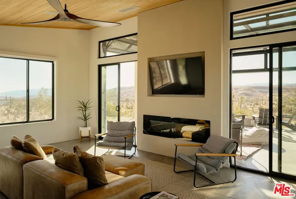 a living room with furniture and a floor to ceiling window