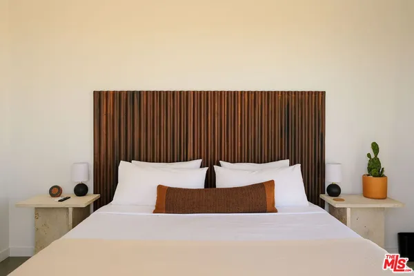 a bedroom with a bed and potted plant