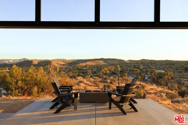 a view of balcony with furniture and mountain view