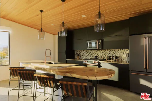 a kitchen with a table chairs and refrigerator