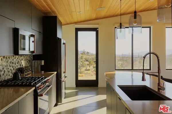 a kitchen with stainless steel appliances granite countertop a sink a stove and a refrigerator