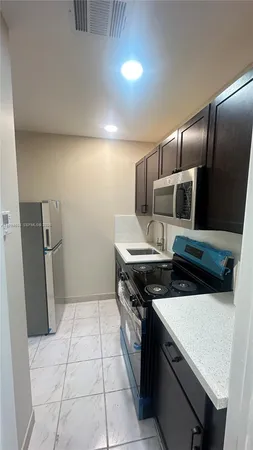 a kitchen with a stove a microwave and a refrigerator
