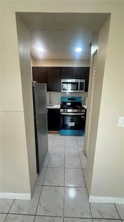 a kitchen with granite countertop a refrigerator and a cabinets