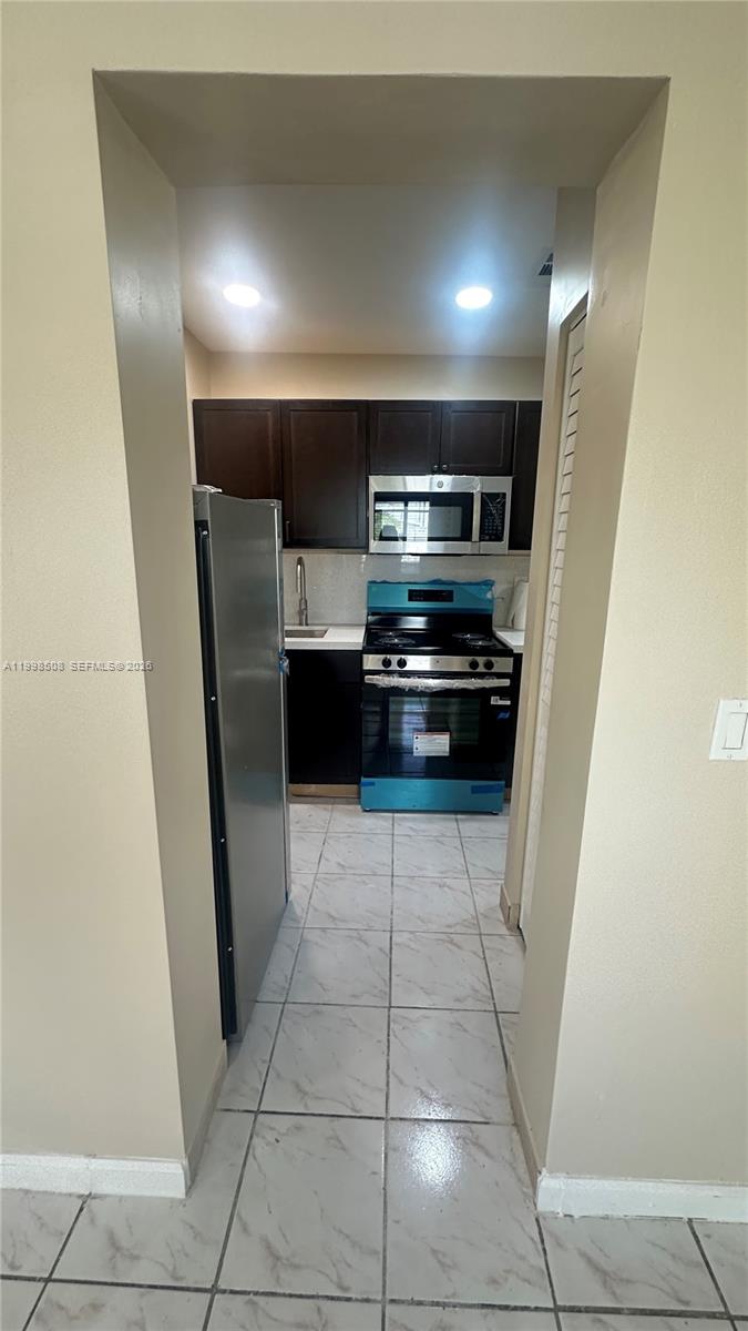 990 East 2nd Street, Unit B Hialeah, FL 33010 - Photo 6 of 12 a kitchen with granite countertop a refrigerator and a cabinets