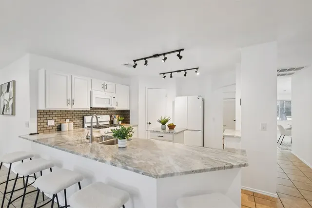 a kitchen with white cabinets and white appliances