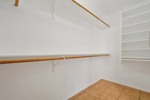 an empty room with a window and a ceiling fan