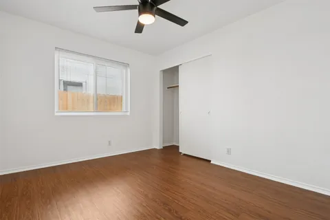 an empty room with a window and a ceiling fan