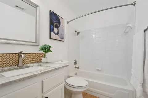 an empty room with wooden floor ceiling fan and windows