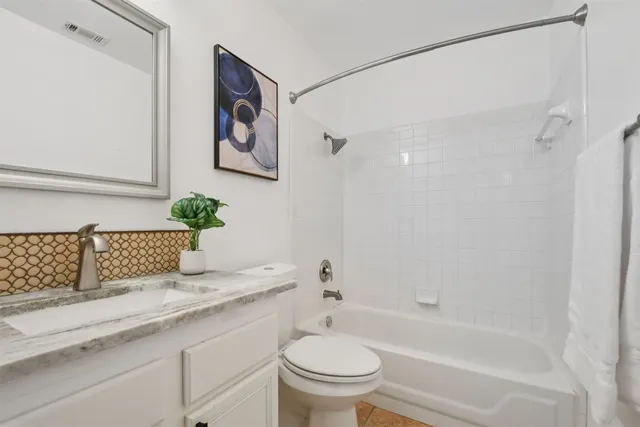 an empty room with wooden floor ceiling fan and windows