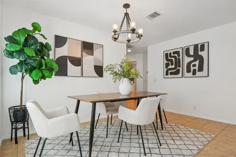 a dining room with furniture potted plants and wooden floor