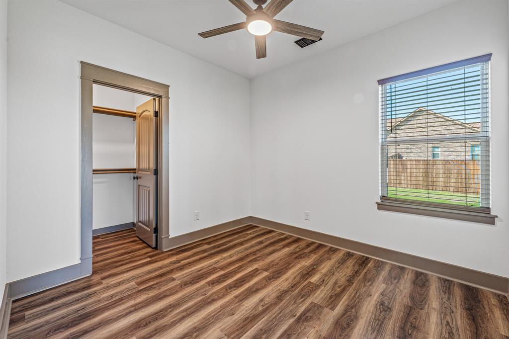 1035 Barton Ranch Road Nemo, TX 76070 - Photo 13 of 28 Unfurnished bedroom with dark wood finished floors, ceiling fan, and a walk in closet