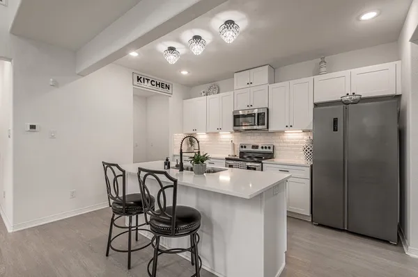 a kitchen with white cabinets and stainless steel appliances