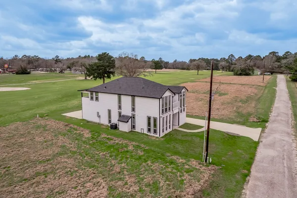 a aerial view of a house with a yard and large trees