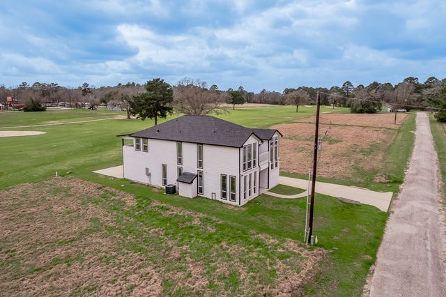 a aerial view of a house with a yard and large trees
