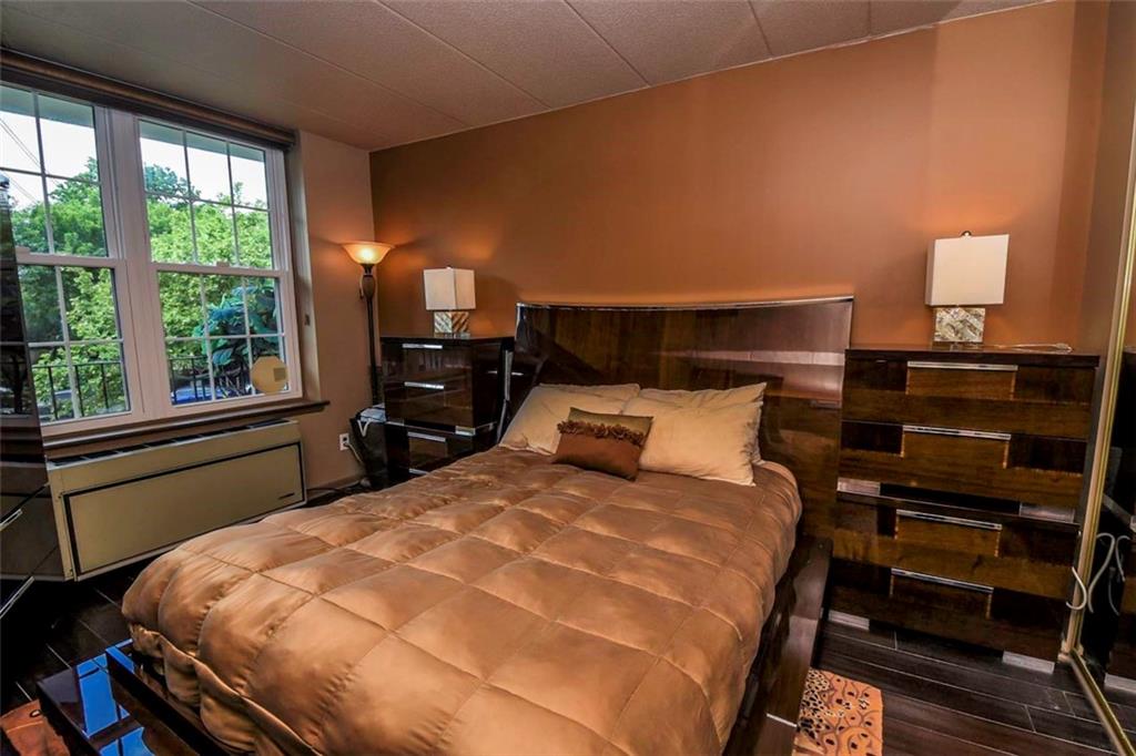 9995 Shore Road, Unit 18C Brooklyn, NY 11209 - Photo 11 of 15 a bed sitting in a bedroom next to a window