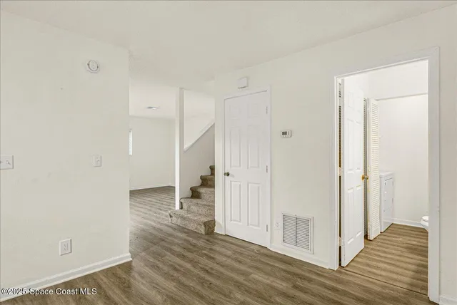 a view of empty room with wooden floor
