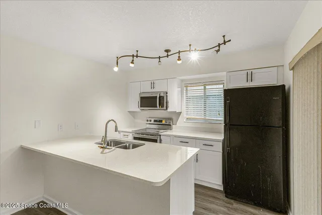 a kitchen with a sink a refrigerator and a stove