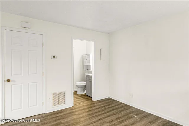 a view of a room with wooden floor and bathroom