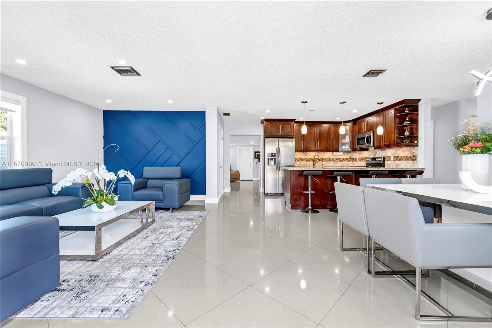 a living room with stainless steel appliances kitchen island granite countertop furniture and a kitchen view
