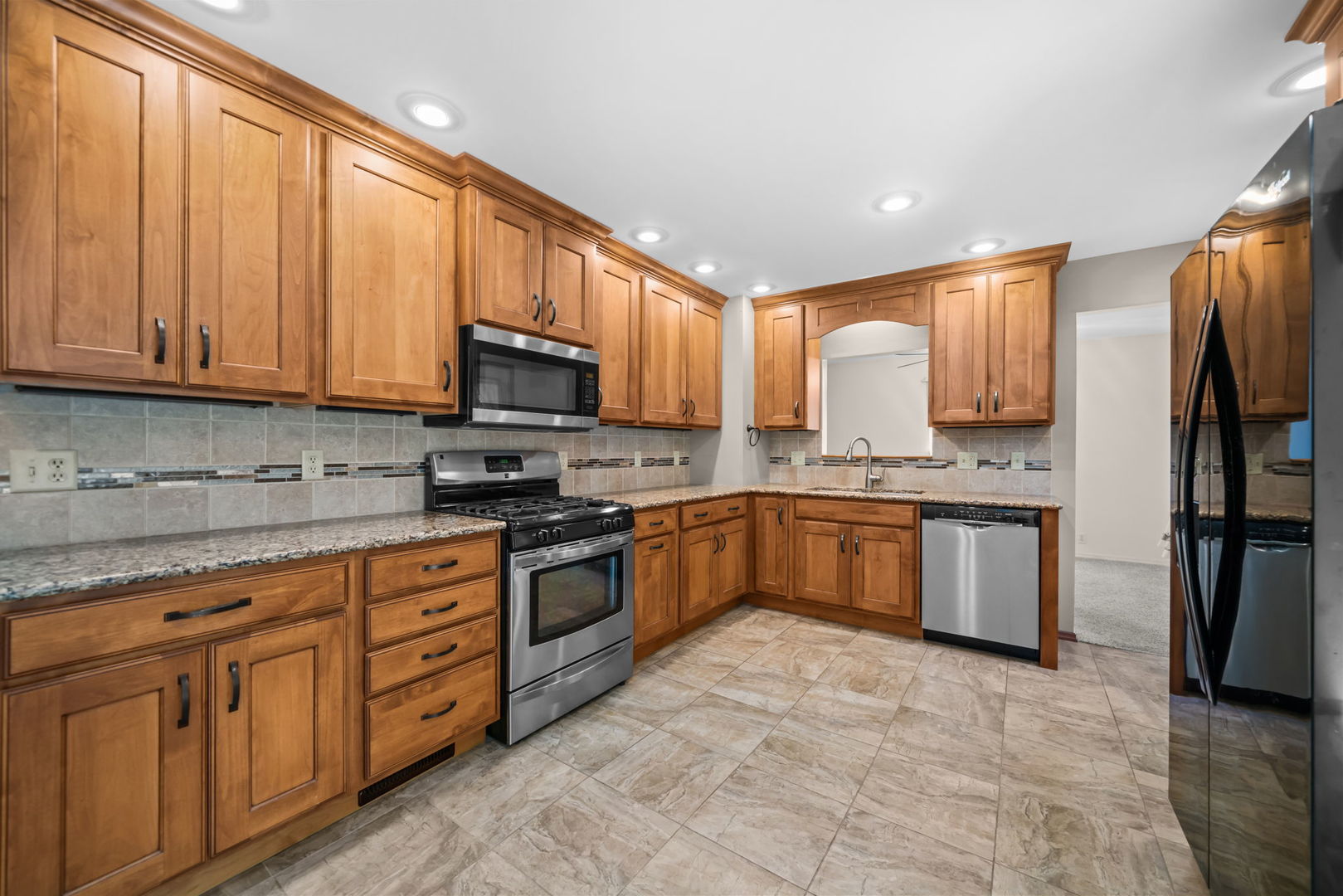 5748 South Skare Road Rochelle, IL 61068 - Photo 2 of 45 a kitchen with stainless steel appliances granite countertop a stove top oven a sink dishwasher and a refrigerator with wooden cabinets